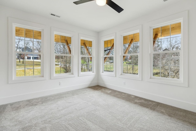 unfurnished sunroom featuring ceiling fan