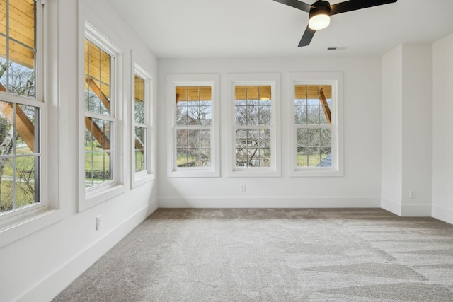 unfurnished sunroom with ceiling fan