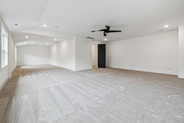 empty room featuring lofted ceiling, light carpet, and ceiling fan