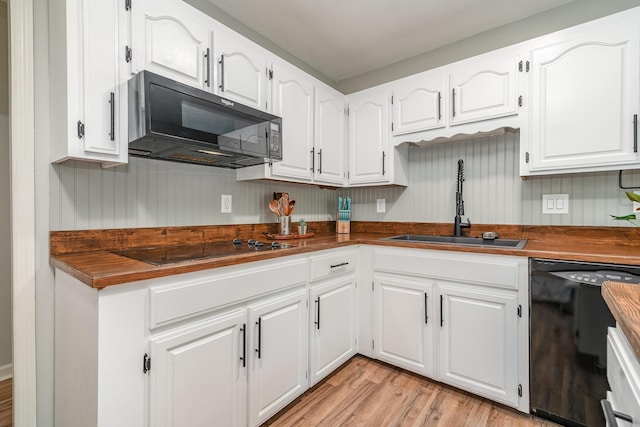 kitchen featuring white cabinets, butcher block counters, sink, and black appliances