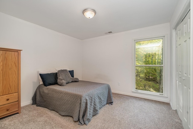 bedroom with light colored carpet and a closet