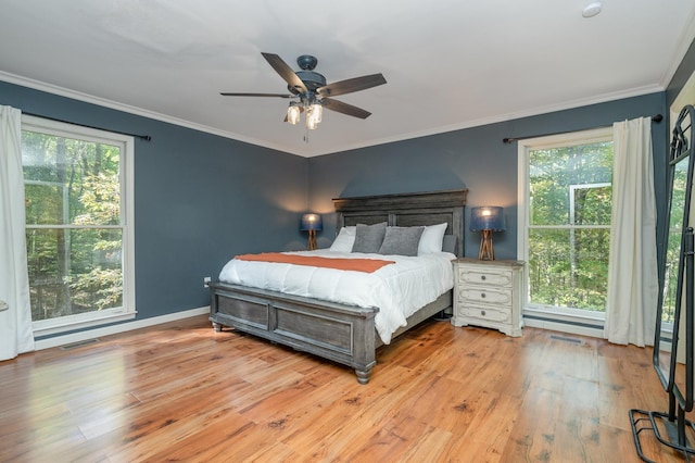 bedroom with multiple windows, crown molding, and light wood-type flooring