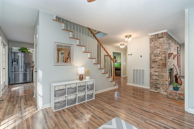 entrance foyer featuring wood-type flooring and a fireplace