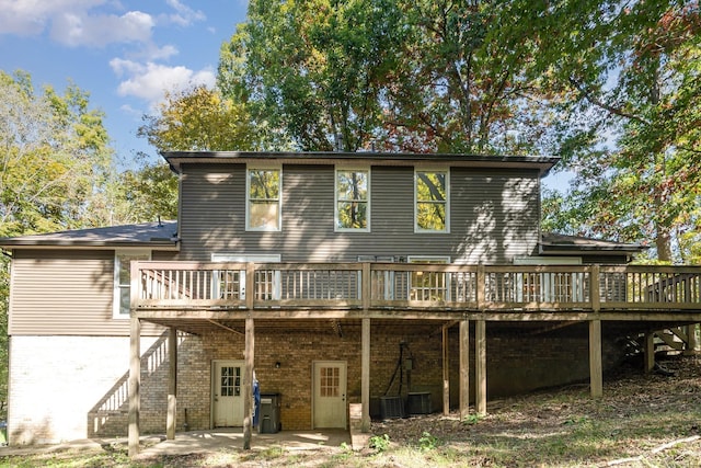 rear view of house with a wooden deck, central AC unit, and a patio