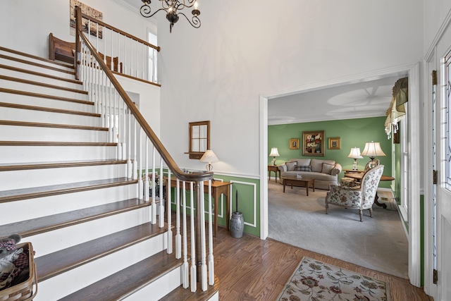 foyer with a towering ceiling, dark hardwood / wood-style flooring, and a notable chandelier