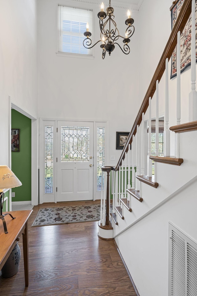 entrance foyer with a wealth of natural light, dark hardwood / wood-style floors, and a high ceiling