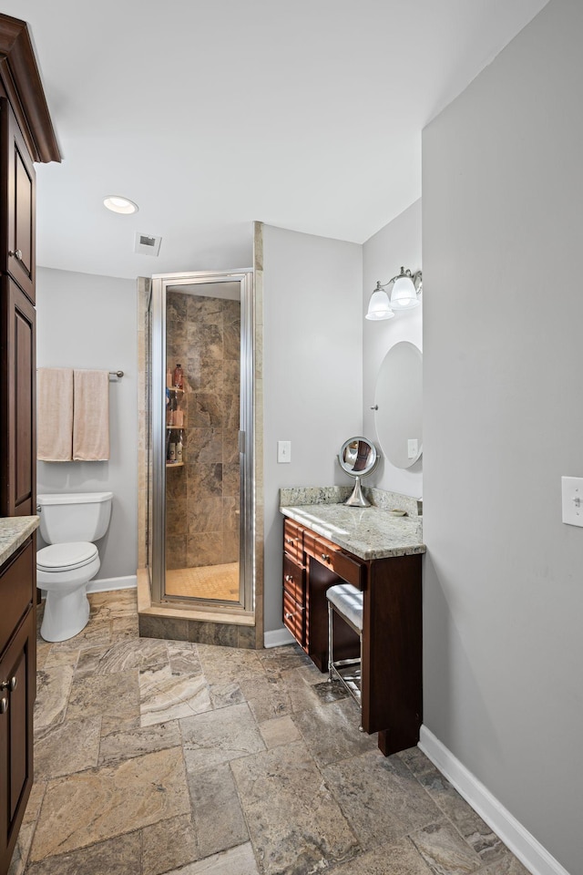 bathroom with a shower with door, vanity, and toilet