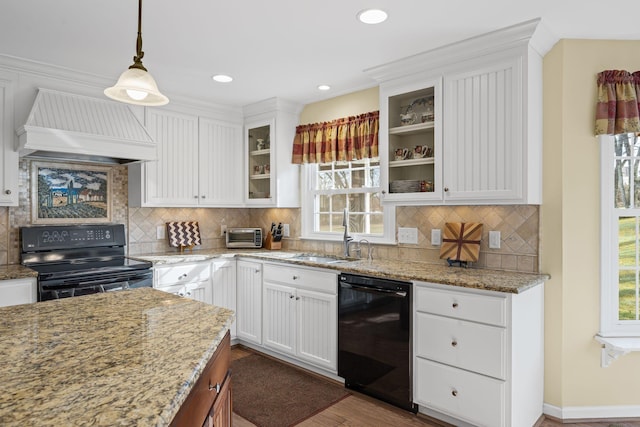 kitchen featuring sink, white cabinetry, decorative light fixtures, custom range hood, and black appliances