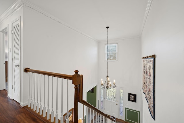 hallway featuring crown molding, dark wood-type flooring, and a notable chandelier