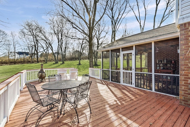 wooden terrace with a sunroom and a yard