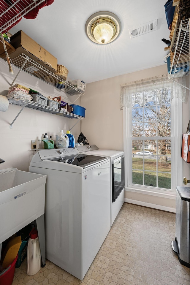 washroom with sink and washing machine and clothes dryer