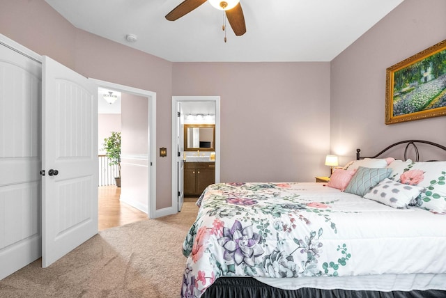 bedroom featuring light carpet, connected bathroom, and ceiling fan