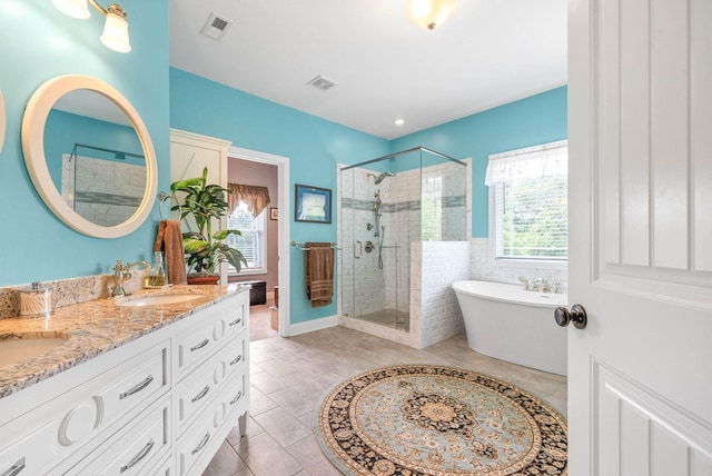 bathroom featuring independent shower and bath, vanity, plenty of natural light, and tile patterned flooring