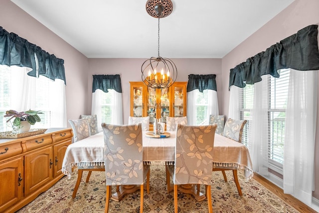 dining space featuring light hardwood / wood-style flooring and a chandelier