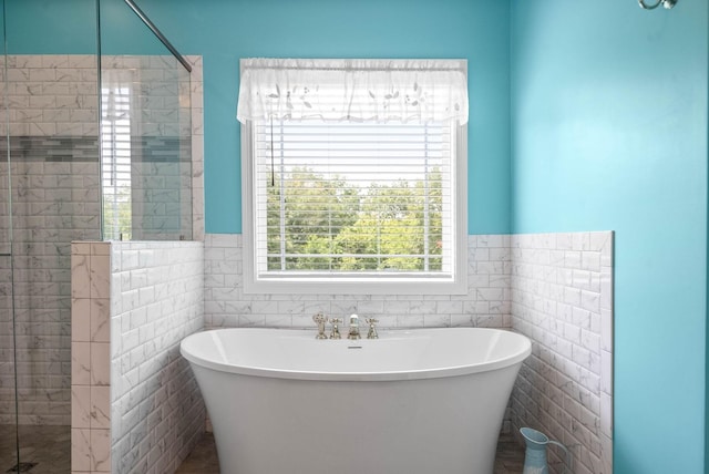 bathroom featuring separate shower and tub and tile walls