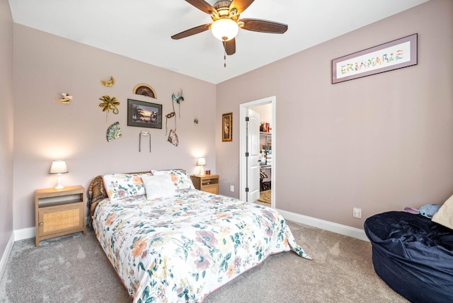 bedroom with ceiling fan, light colored carpet, and a walk in closet