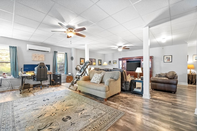 living room featuring ceiling fan, a paneled ceiling, a wall mounted AC, and hardwood / wood-style floors