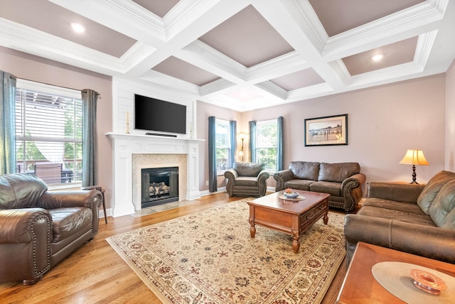 living room with a large fireplace, plenty of natural light, beam ceiling, and light wood-type flooring