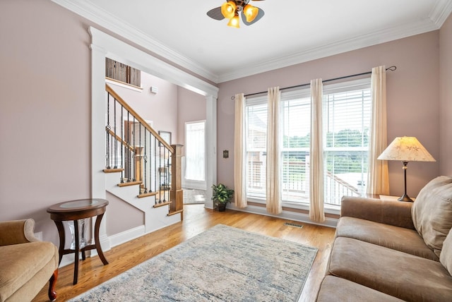 living room with crown molding, ceiling fan, and light hardwood / wood-style floors