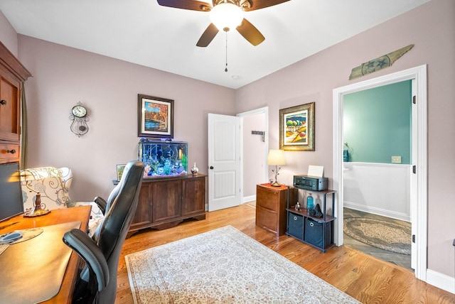 home office with ceiling fan and light hardwood / wood-style flooring