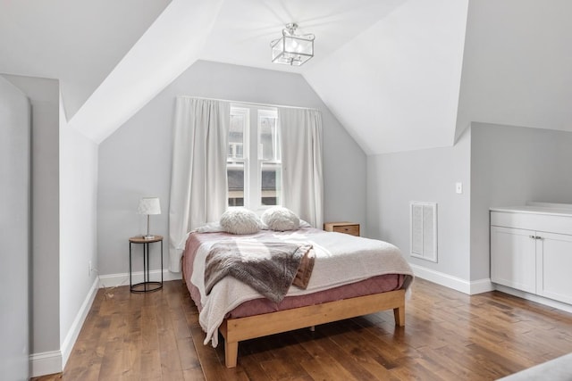 bedroom with lofted ceiling, a notable chandelier, and hardwood / wood-style flooring