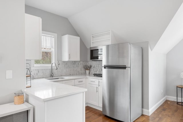 kitchen with sink, kitchen peninsula, white cabinets, and appliances with stainless steel finishes