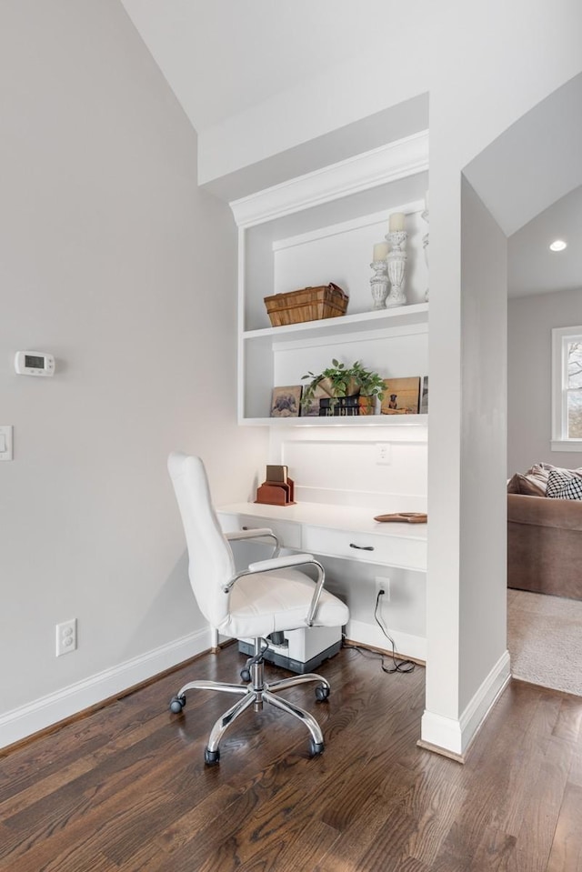 living area featuring lofted ceiling, built in desk, and hardwood / wood-style floors