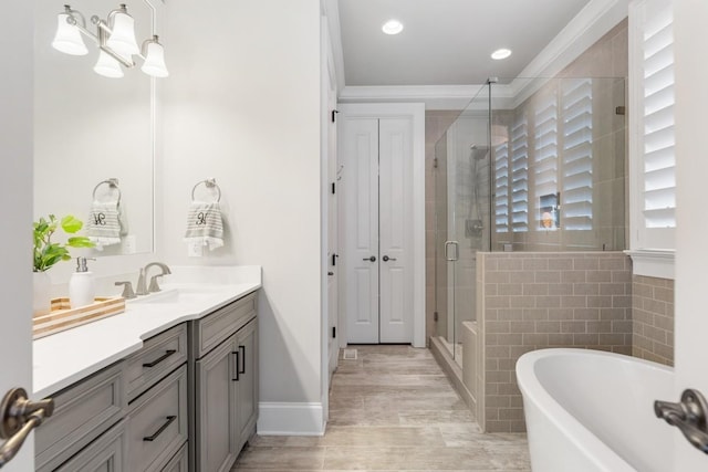 bathroom featuring crown molding, vanity, and separate shower and tub