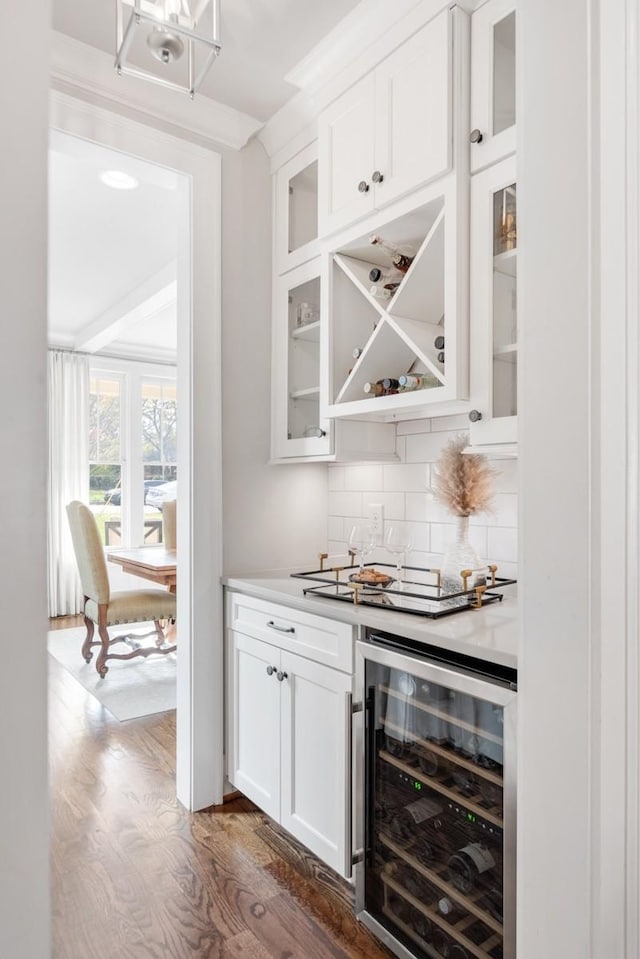 bar featuring white cabinets, dark hardwood / wood-style floors, wine cooler, and decorative backsplash