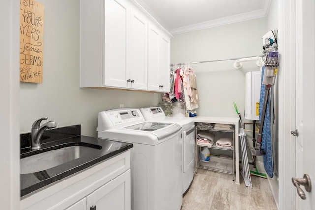 washroom with sink, ornamental molding, cabinets, and independent washer and dryer