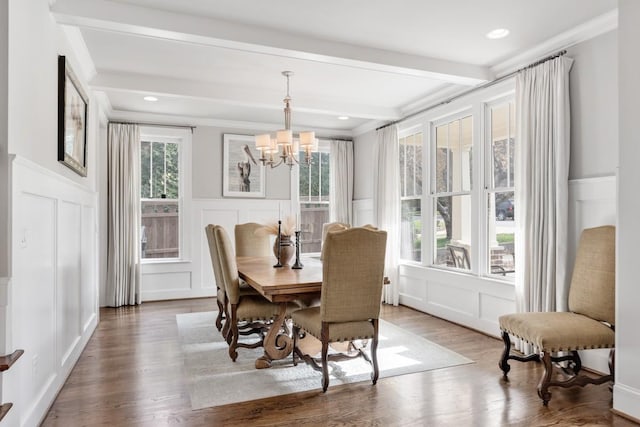 dining area with hardwood / wood-style flooring, ornamental molding, an inviting chandelier, and beam ceiling