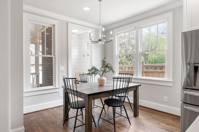 dining room featuring crown molding, a chandelier, and dark hardwood / wood-style flooring