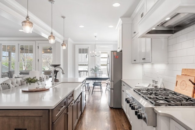 kitchen featuring white cabinetry, hanging light fixtures, stainless steel appliances, and custom range hood