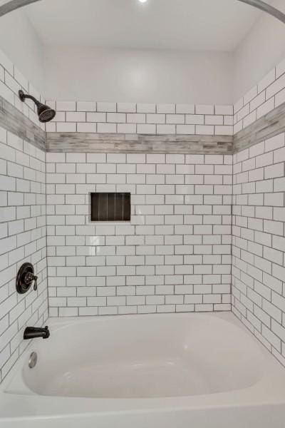 bathroom featuring tiled shower / bath