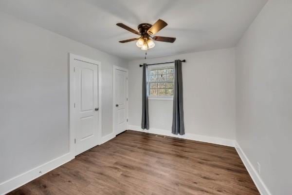 spare room featuring dark wood-type flooring and ceiling fan