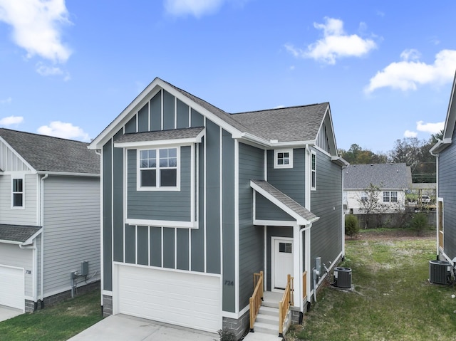 view of front of house with a garage, central AC unit, and a front lawn