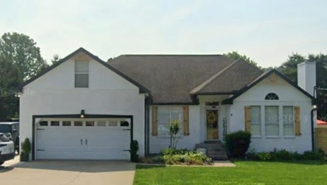 view of front of property featuring a garage and a front lawn