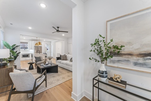 living room with ceiling fan and light wood-type flooring