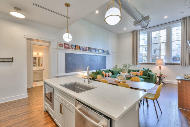 kitchen with white cabinetry, appliances with stainless steel finishes, sink, and pendant lighting