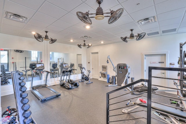 workout area with ceiling fan and a paneled ceiling