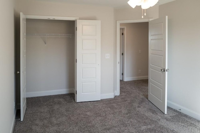 unfurnished bedroom featuring dark colored carpet and a closet