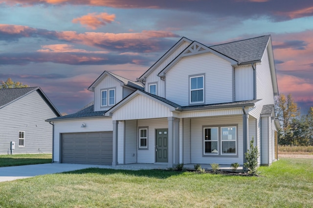 view of front of house featuring a porch, a yard, and a garage