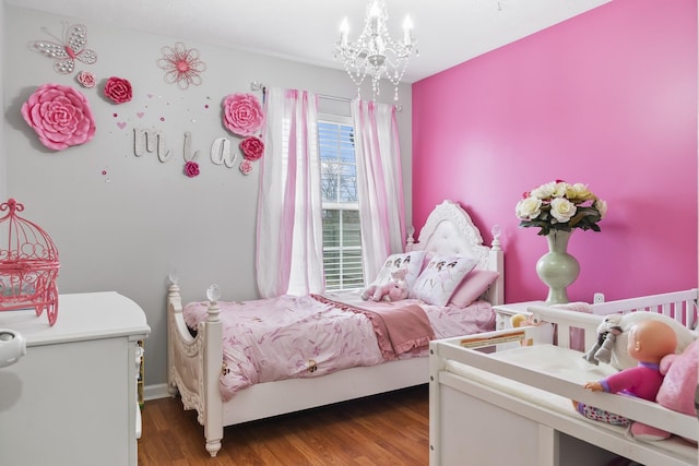 bedroom with hardwood / wood-style floors and a chandelier