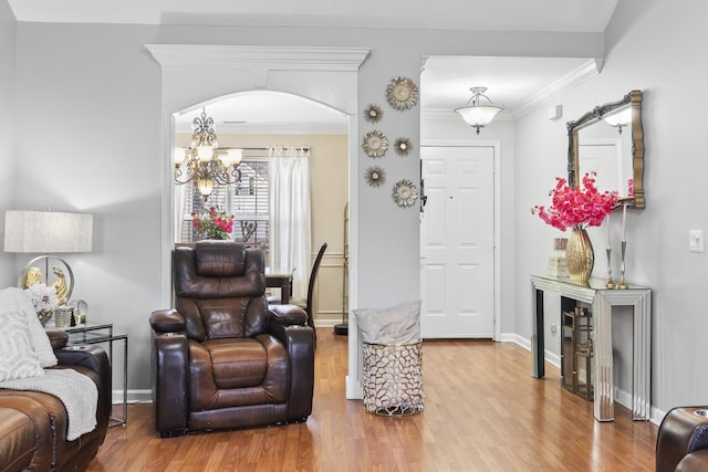 living room featuring an inviting chandelier, hardwood / wood-style floors, and ornamental molding