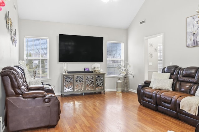 living room with hardwood / wood-style floors and high vaulted ceiling