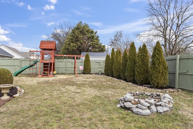 view of yard featuring a playground and a fire pit