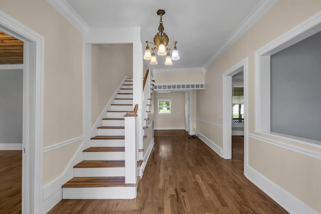 staircase with hardwood / wood-style flooring, crown molding, and an inviting chandelier