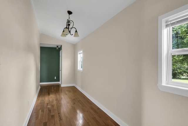 interior space with vaulted ceiling, wood-type flooring, and a notable chandelier