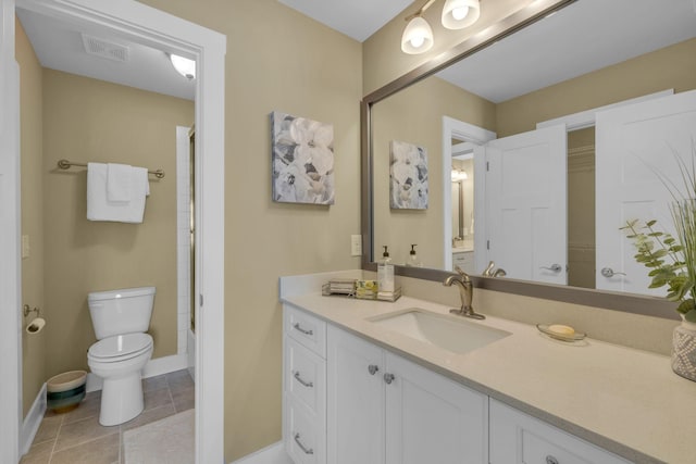 bathroom featuring vanity, a shower, tile patterned floors, and toilet