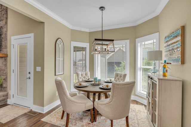 dining room with ornamental molding, a notable chandelier, and dark hardwood / wood-style flooring